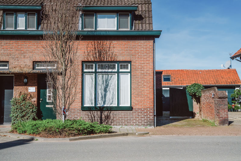 Het huis vanaf de straat gezien. Je moet door de groene poort.